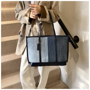 Detail der blauen Patchwork-Tragetasche mit Lederriemen und strukturierten Stoffmaterialien
