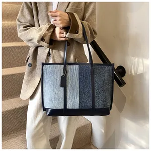 Detailansicht der Denim-Tasche in Patchwork-Optik mit Lederriemen und Anhänger
