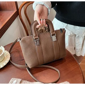 Macro view of brown striped handbag texture with high-quality pleats and silver zipper