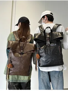 Detail of roll-top vintage leather backpacks with plush bear charm and buckle straps