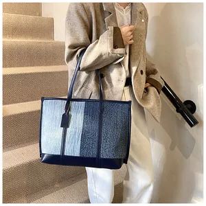 Detail der zweifarbigen Denim-Eimertasche am Model für einen modischen Pendler-Look