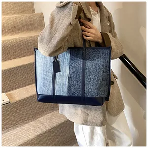 Modische Denim-Einkaufstasche mit Kontrastfarben am Modell für einen lässigen Look