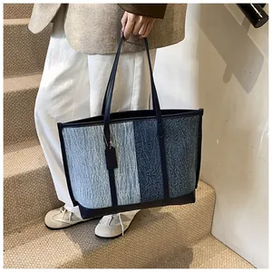 Detailansicht der Denim-Patchwork-Tragetasche mit hochwertigen blauen Ledergriffen