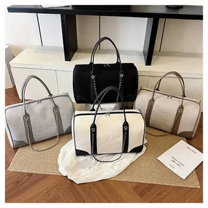 Group of large contrast canvas tote bags in black, beige, and brown with chain details
