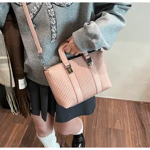 Detail of pink pleated faux leather tote bag with silver buckle and thin strap