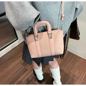 Detail of pink pleated texture and silver buckle on chic tote bag shown on model