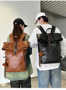 Rear view of two large vintage PU leather backpacks in black and brown with bear charm