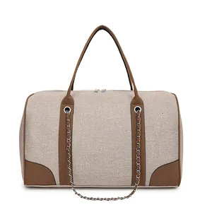 Detail view of the large canvas tote bag with brown leather handles and dual zipper closure