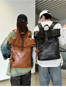 Detail view of brown and black roll-top PU leather backpacks with metal buckles and plush charms