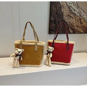 Detail of suede tote bags with plush shearling trim and cute crochet bear charm accessories