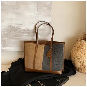 Detail der Kontrast-Tote-Bag mit braunem Lederriemen und gemischten Wollstoff-Texturen