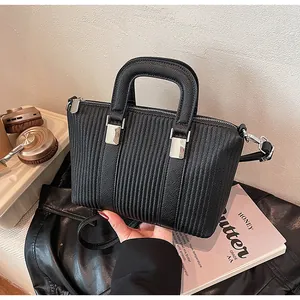 Close-up of black lychee grain leather tote with vertical pleated design and silver hardware