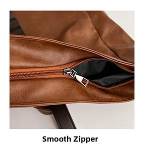 Macro shot of smooth metal zipper and pebbled texture on brown leather bag detail
