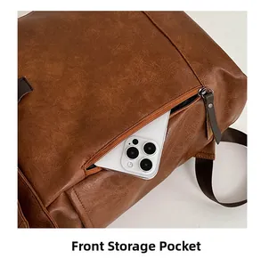 Front zipper storage pocket on brown leather backpack showing space for a smartphone