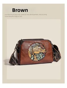 Detail of vintage brown leather pillow bag with elephant relief and wide woven strap