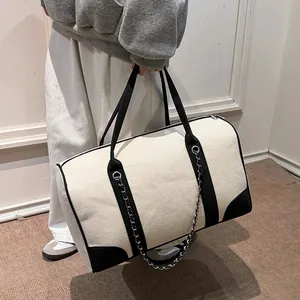 Large contrast color canvas tote bag with metal chain detail for travel and commuting