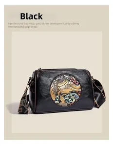 Detail of vintage black leather bag featuring an embossed ethnic elephant and wide strap
