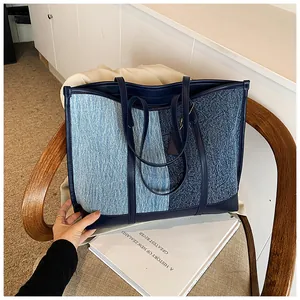 Detail der Kontrast-Denim-Tragetasche mit blauem Patchwork-Stoff und Ledergriffen