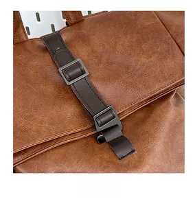 Detail of brown faux leather backpack with matte metal buckle and textured flap