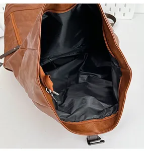 Internal view of the brown leather backpack showing a black fabric lining and zippered pocket