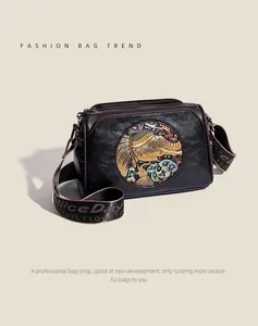 Detail of vintage embossed elephant pattern and textured leather on a crossbody bag