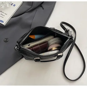 Top-down view of black quilted tote bag interior holding phone, wallet and cosmetics