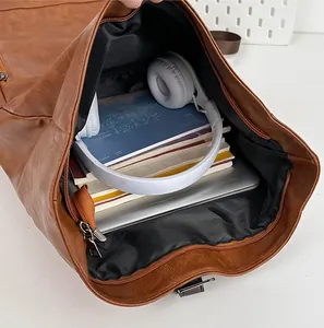 Top view of spacious brown PU backpack interior with laptop and books for commuting