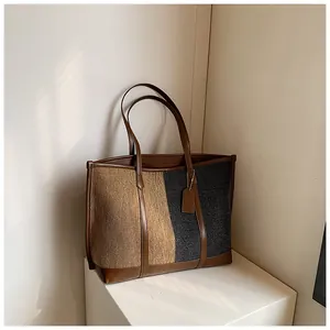 Detail der Kontrastfarben-Tote Bag mit braunen Ledergriffen auf weißem Display