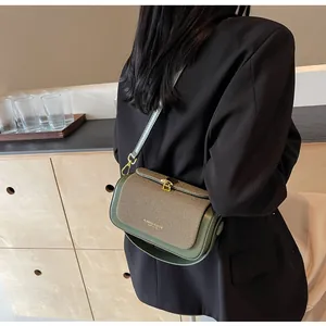 Détail du cuir vert armée et du tissu tissé beige sur le sac bandoulière avec fermoir doré