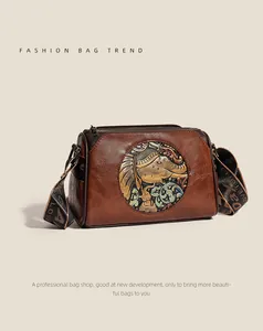 Macro detail of brown leather pillow bag featuring an elephant embossed metal emblem