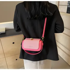 Détail du sac bandoulière rose avec tissu texturé et boucle dorée élégante