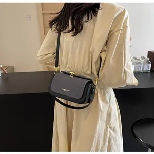 Détail du sac bandoulière bicolore en cuir noir avec rabat en texture tissée grise