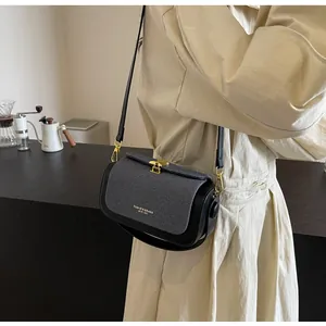 Détail du sac à bandoulière contrasté en denim bleu et fermoir tournant doré