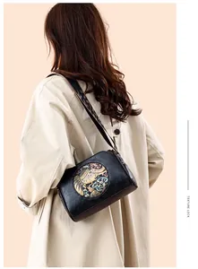 Detail of vintage black leather pillow bag featuring floral elephant embossed pattern