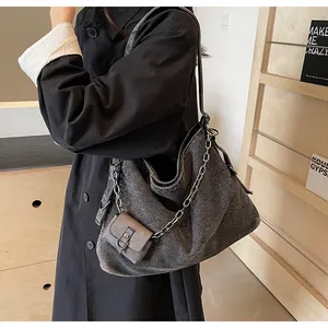 Detail of grey denim tote bag with silver chain and mini pouch on autumn trench coat