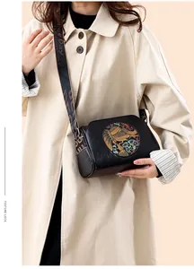 Detail of vintage black embossed bag with colorful circular relief and wide strap