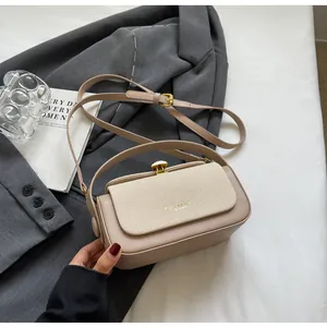 Détail d'un sac bandoulière beige avec rabat tissé et fermoir en métal doré chic