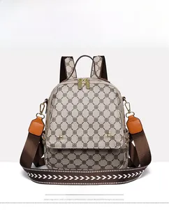 Front view of grey vintage pattern backpack with brown leather straps and gold rivets