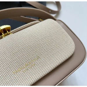 Gros plan du tissu texturé beige et du cuir kaki avec boucle en métal doré
