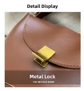 Detailed macro view of a golden metal clasp on a textured caramel brown leather handbag