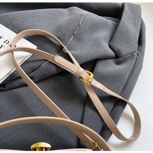 Détail de la bandoulière beige en cuir PU avec boucle métallique dorée réglable