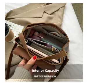 Internal capacity view of a brown leather shoulder bag with multiple compartments