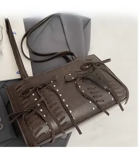 Detail of dark brown retro shoulder bag with bow weaving and silver metal rivets