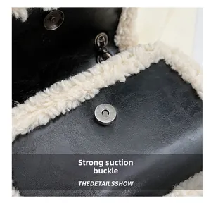 Detail of strong magnetic closure on black litchi leather and beige faux fur shoulder bag