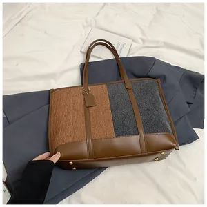 Detailansicht der kontrastfarbenen Tragetasche mit Materialtexturen und goldenen Nieten
