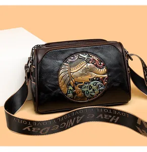 Close-up of vintage embossed leather bag featuring an elephant and floral relief design
