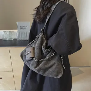Large denim tote bag with silver chain strap and mini pouch shown on model