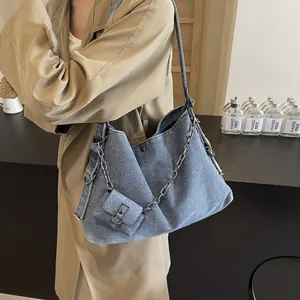 Blue denim tote bag with silver chain and mini pouch on model in retro khaki trench coat