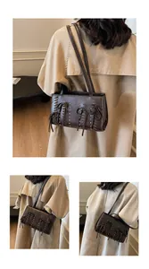 Detail of dark brown faux suede bag with lace-up weaving and rivet decorations