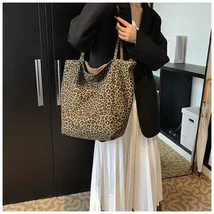 Detailed view of leopard print tote bag styled with a professional blazer and skirt